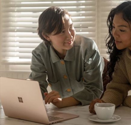 Child and woman look at a laptop