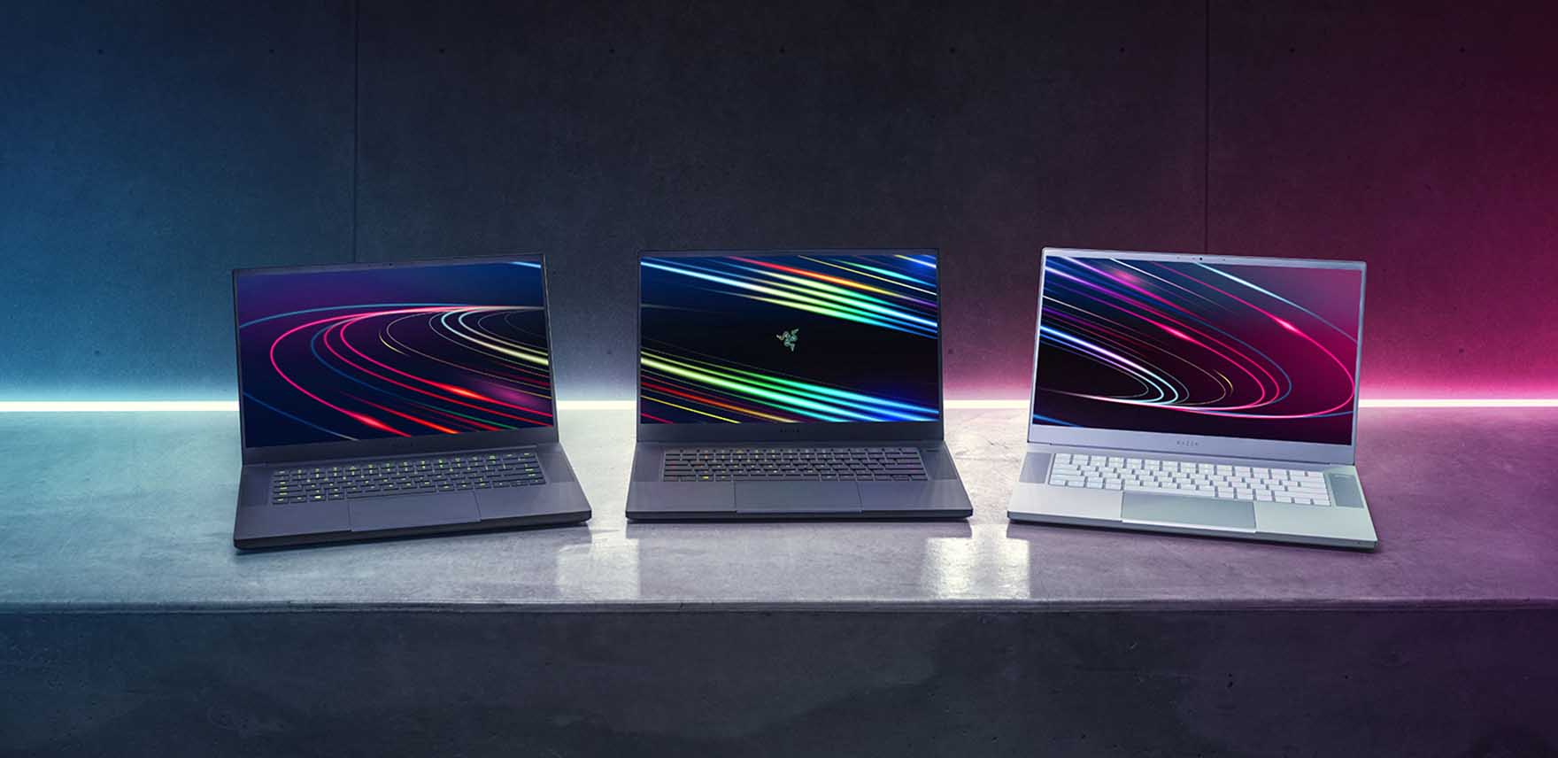 Three Razer Blade 15 laptops on a table, open and facing readers