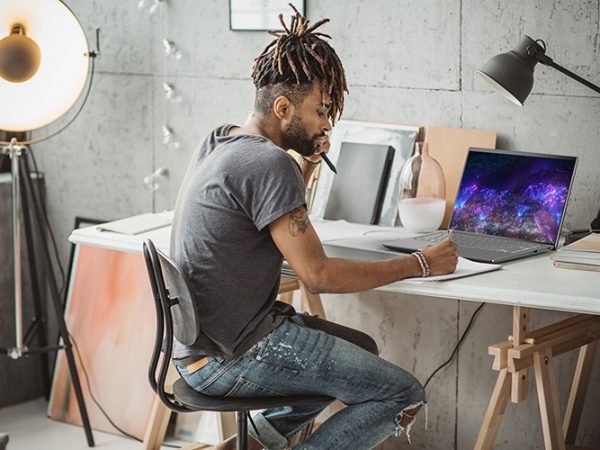 Man at a desk working on an Acer Swift 3 OLED laptop