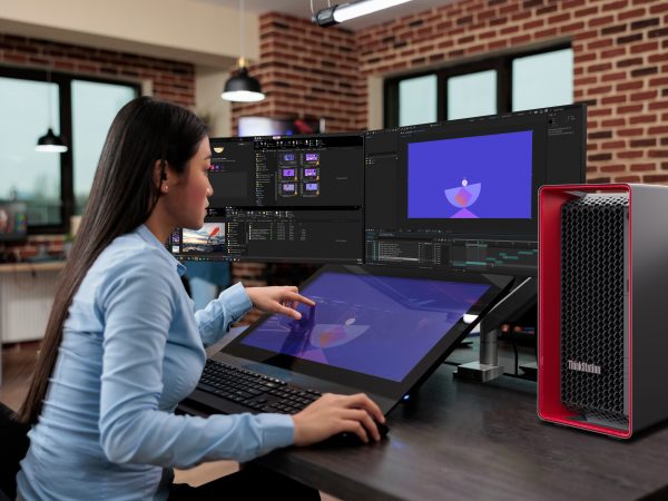 Woman sitting in front of two PC displays